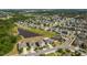 A high aerial view of a suburban neighborhood featuring well-maintained lawns and a small lake nearby at 10013 Caraway Spice Ave, Riverview, FL 33578