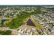 A high aerial shot showcasing a suburban community alongside a pond and lush greenery at 10013 Caraway Spice Ave, Riverview, FL 33578