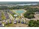 Aerial view showcases a suburban community with a lake, pool, and winding streets at 10013 Caraway Spice Ave, Riverview, FL 33578