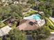 Aerial view of a community pool, recreation center, and playground, surrounded by lush landscaping and mature trees at 10013 Caraway Spice Ave, Riverview, FL 33578