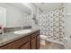 Bathroom with a granite countertop vanity, a large mirror, and a shower with a patterned curtain at 10013 Caraway Spice Ave, Riverview, FL 33578