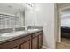 Bathroom with double granite sinks and a mirror, and access to the shower and the bedroom at 10013 Caraway Spice Ave, Riverview, FL 33578