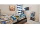 Bedroom showcasing a dark wooden bed frame with a video game theme and a window with striped curtains at 10013 Caraway Spice Ave, Riverview, FL 33578