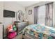 Bedroom featuring a bed with colorful butterfly pattern bedding, gray curtains, and a mounted TV at 10013 Caraway Spice Ave, Riverview, FL 33578