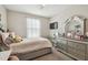 Bedroom showcasing a full bed with a light floral print, dresser, and sheer curtains allowing ample natural light at 10013 Caraway Spice Ave, Riverview, FL 33578