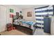 Bedroom featuring a dark wooden bed frame with a gaming theme and a window with striped curtains at 10013 Caraway Spice Ave, Riverview, FL 33578