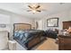 Spacious bedroom with a ceiling fan, a large mirror over a dresser, and an elegant king bed at 10013 Caraway Spice Ave, Riverview, FL 33578