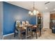 Dining room boasts a modern chandelier and seating for four and three attached high chairs at 10013 Caraway Spice Ave, Riverview, FL 33578