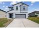 Two-story home boasts a modern design, two-car garage, and well-manicured lawn in a suburban neighborhood at 10013 Caraway Spice Ave, Riverview, FL 33578