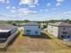 Two-story home shows spacious backyard, blue sky, fluffy white clouds, and nearby lake at 10013 Caraway Spice Ave, Riverview, FL 33578