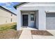 Inviting entryway with dark front door, decorative welcome sign, and modern exterior finishes at 10013 Caraway Spice Ave, Riverview, FL 33578
