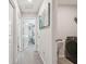 Hallway with carpet and white walls and leads to a bedroom and a laundry room with front loading washer at 10013 Caraway Spice Ave, Riverview, FL 33578