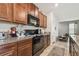 Modern kitchen featuring dark cabinets, granite counters, and black appliances at 10013 Caraway Spice Ave, Riverview, FL 33578