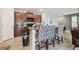 Kitchen featuring dark cabinetry, granite counters, stainless steel appliances, and bar seating at 10013 Caraway Spice Ave, Riverview, FL 33578