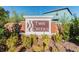A view of the Twin Creeks community sign surrounded by manicured landscaping and a glimpse of a home in the background at 10148 Rose Petal Pl, Riverview, FL 33578