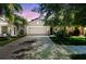 Two-story home featuring a neutral gray exterior, two-car garage, well-manicured lawn and mature landscaping at 10148 Rose Petal Pl, Riverview, FL 33578