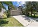 Charming two-story home featuring a neutral gray exterior, two-car garage, well-manicured lawn and mature landscaping at 10148 Rose Petal Pl, Riverview, FL 33578