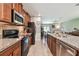 Charming kitchen featuring granite countertops, wood cabinets, and stainless steel appliances at 10148 Rose Petal Pl, Riverview, FL 33578
