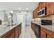 Charming kitchen featuring granite countertops, wood cabinets, and stainless steel appliances at 10148 Rose Petal Pl, Riverview, FL 33578
