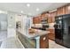 Well-equipped kitchen featuring wood cabinets, stainless steel appliances, ample counter space, and modern lighting at 10148 Rose Petal Pl, Riverview, FL 33578