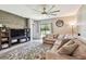Bright living room with large sectional sofa, media center, and sliding glass doors to backyard at 10148 Rose Petal Pl, Riverview, FL 33578
