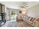 Spacious living room with large sectional sofa, sliding glass doors, and large ceiling fan at 10148 Rose Petal Pl, Riverview, FL 33578