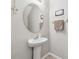 Cozy powder room featuring a pedestal sink, an oval mirror, decorative accents, and neutral color scheme at 10148 Rose Petal Pl, Riverview, FL 33578