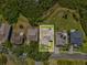 Aerial view of a cozy home nestled within lush greenery with a well-maintained lawn at 1015 S Pointe Alexis Dr, Tarpon Springs, FL 34689