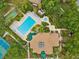 Aerial view featuring a pool, clubhouse, and surrounding landscaping at 1015 S Pointe Alexis Dr, Tarpon Springs, FL 34689