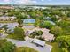 A landscape of ponds, tennis courts, and a common parking area surrounded by trees and homes at 1015 S Pointe Alexis Dr, Tarpon Springs, FL 34689