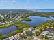 Stunning aerial view showcases waterfront home on a lake with beautiful landscaping and community at 1015 S Pointe Alexis Dr, Tarpon Springs, FL 34689