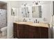 Elegant bathroom featuring a double vanity with a curved countertop, ample cabinet storage, and stylish lighting fixtures at 1015 S Pointe Alexis Dr, Tarpon Springs, FL 34689