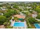 Overhead shot of a community pool with ample lounge chairs and tropical landscaping, perfect for relaxation at 1015 S Pointe Alexis Dr, Tarpon Springs, FL 34689