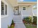 Inviting front porch with steps leading to the front door and lush landscaping at 1015 S Pointe Alexis Dr, Tarpon Springs, FL 34689
