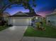 Charming single-story home featuring a well-manicured front yard, a driveway, and an attached garage at 1015 S Pointe Alexis Dr, Tarpon Springs, FL 34689