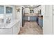 Kitchen featuring two-tone cabinetry, stainless steel appliances, tile floors, and counter seating at 1015 S Pointe Alexis Dr, Tarpon Springs, FL 34689