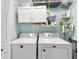 Functional laundry room with modern appliances, overhead cabinets, and shelving for organized storage and convenience at 1015 S Pointe Alexis Dr, Tarpon Springs, FL 34689