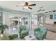Bright living room with palm-patterned chairs, access to deck with grill, and an open floor plan at 1015 S Pointe Alexis Dr, Tarpon Springs, FL 34689
