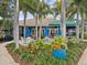Clubhouse patio featuring outdoor seating, lush greenery, and palm trees at 1015 S Pointe Alexis Dr, Tarpon Springs, FL 34689