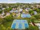 Aerial view showcasing well-maintained tennis courts surrounded by mature trees in a serene community at 1015 S Pointe Alexis Dr, Tarpon Springs, FL 34689
