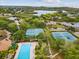 Aerial view of tennis courts and a community pool within a beautifully landscaped residential area at 1015 S Pointe Alexis Dr, Tarpon Springs, FL 34689