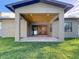 Covered back porch with wood ceiling, offering an inviting outdoor living space with access to the lush backyard at 1017 W Charter St, Tampa, FL 33602