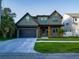 Charming two-story home with a craftsman facade, attached garage, and a well-manicured lawn at 1017 W Charter St, Tampa, FL 33602