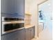 Modern kitchen with stainless steel oven, sleek blue cabinetry, butcher block countertops and open shelving at 1017 W Charter St, Tampa, FL 33602