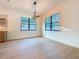 Open living room with hardwood floors, modern light fixture, and large windows at 1017 W Charter St, Tampa, FL 33602