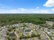An aerial view of a residential community with mature trees and pond views under a beautiful blue sky at 11220 Godwit Ct, New Port Richey, FL 34654