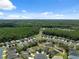 Aerial view of a quiet neighborhood surrounded by lush green forest and a small pond at 11220 Godwit Ct, New Port Richey, FL 34654