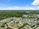 Aerial view of a quiet neighborhood surrounded by lush green forest and a small pond at 11220 Godwit Ct, New Port Richey, FL 34654
