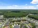 An aerial view of a residential community with mature trees, lawns and a pond under a blue sky at 11220 Godwit Ct, New Port Richey, FL 34654