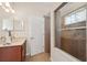 Well-lit bathroom with a glass-enclosed shower and dual vanity at 11220 Godwit Ct, New Port Richey, FL 34654